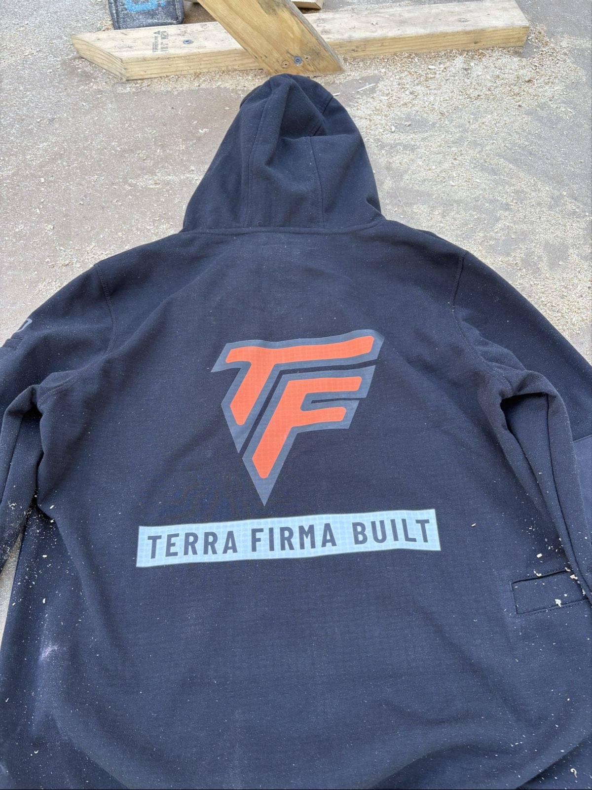 A Terra Firma Built hoodie with its printed back logo, on site